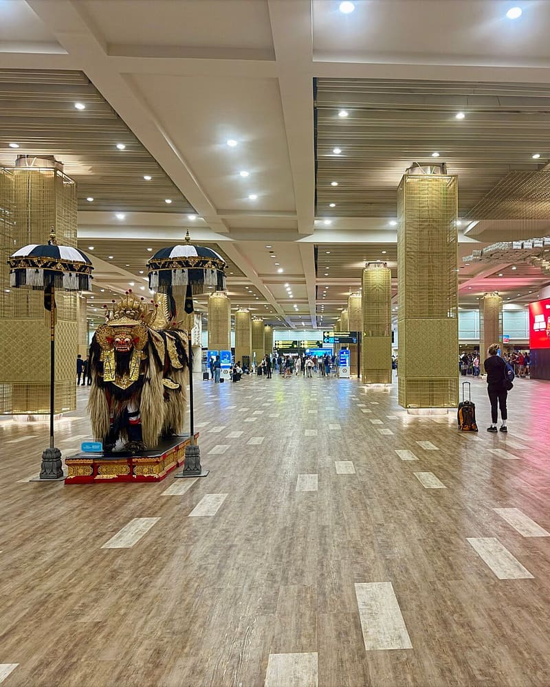 Arrivals hall at Bali's Ngurah Rai International Airport with Balinese Barong statues